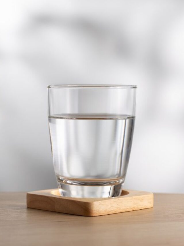 Copo de água limpa sobre uma mesa, representando água filtrada e alcalina.