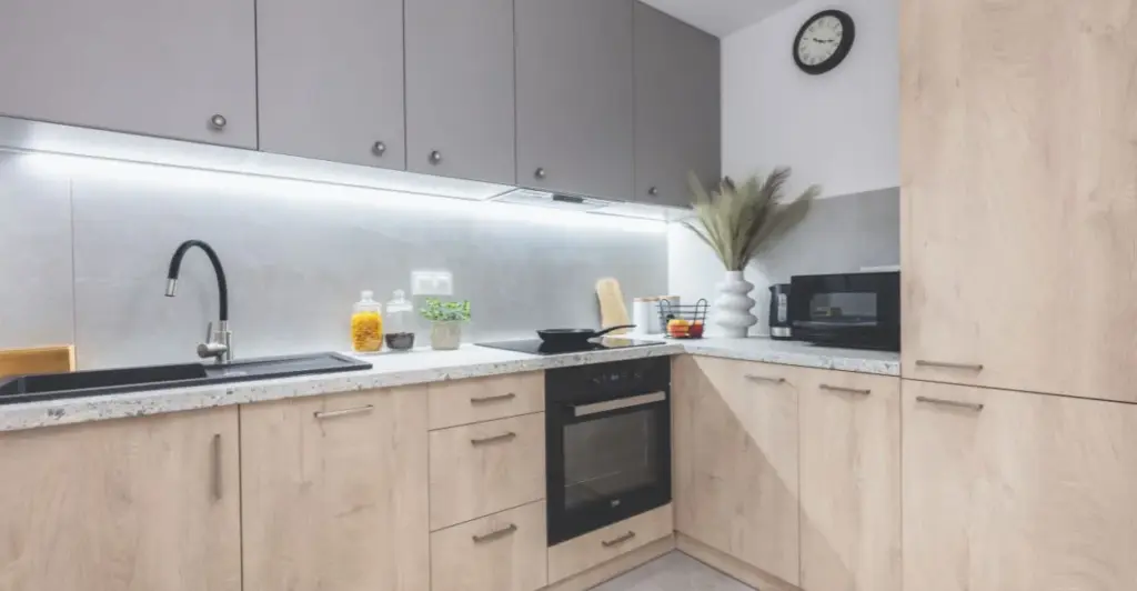 Bancada de cozinha em apartamento pequeno com espaço vazio sob a pia, mostrando área perfeita para instalação de purificador de água compacto